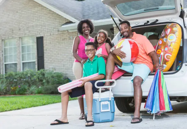 Photo of Family packing car for trip to the beach or pool