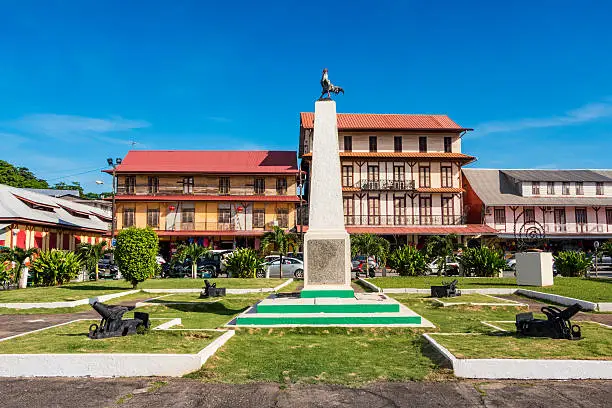 Stock photo of Place du Coq (Rooster Square) with a monument dedicated to the heroes of the First World War 1914-1918, toped with the Gallic rooster, in downtown Cayenne, the capital city of French Guiana, South America. The Gallic rooster is a symbol of historic French roots.