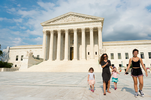 Washington DC, USA - June 24, 2016: A woman and children walk away from the U.S. Supreme Court after taking a few pictures while sightseeing in Washington D.C.