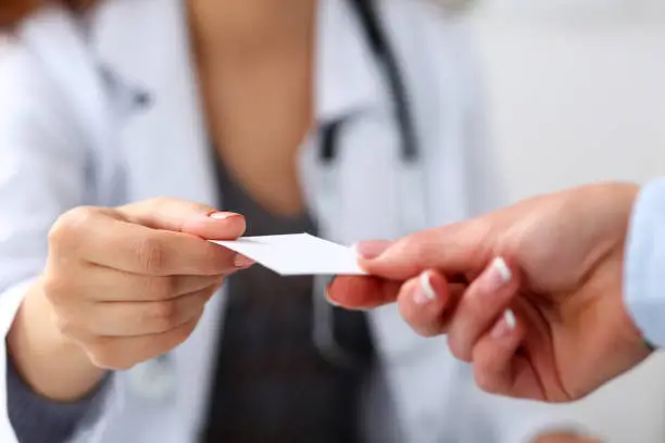 Photo of Female physician hand give white blank calling card