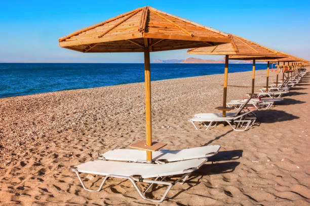 istock Bamboo beach umbrellas with sunbeds on empty beach 639883906