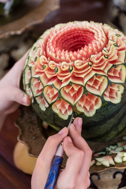 lady's hand crafting watermelon in a floral pattern lady's hand crafting watermelon in a floral pattern fruit carving stock pictures, royalty-free photos & images