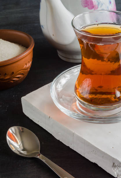 istock Transparent cup of thin glass and black tea. Spoon. 639890494
