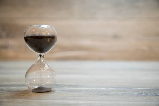istock Hourglass on wooden background 639892690