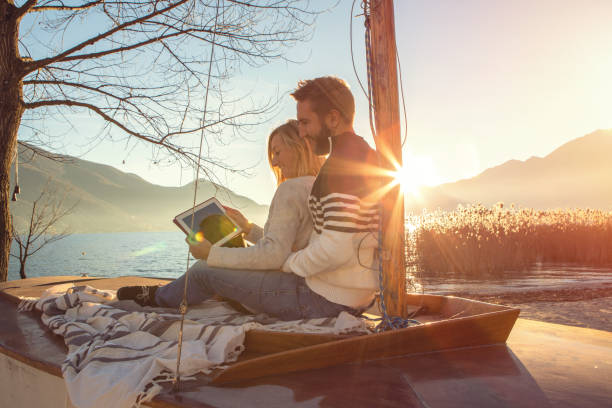 istock Young couple relaxing by the lake using digital tablet 639893674
