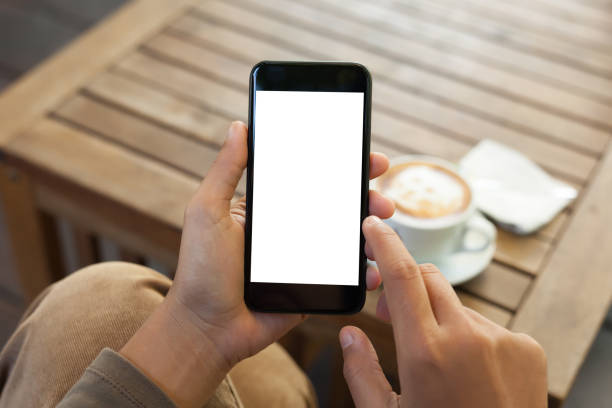 hand holding phone blank screen and finger touching close-up hand holding phone mobile blank screen and finger touching in coffee shop podcast mobile stock pictures, royalty-free photos & images