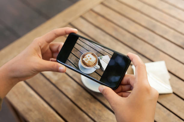 istock hand holding phone mobile taking photo coffee on table 639895786
