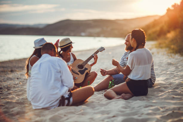 Silhouette of young man making music at the beach