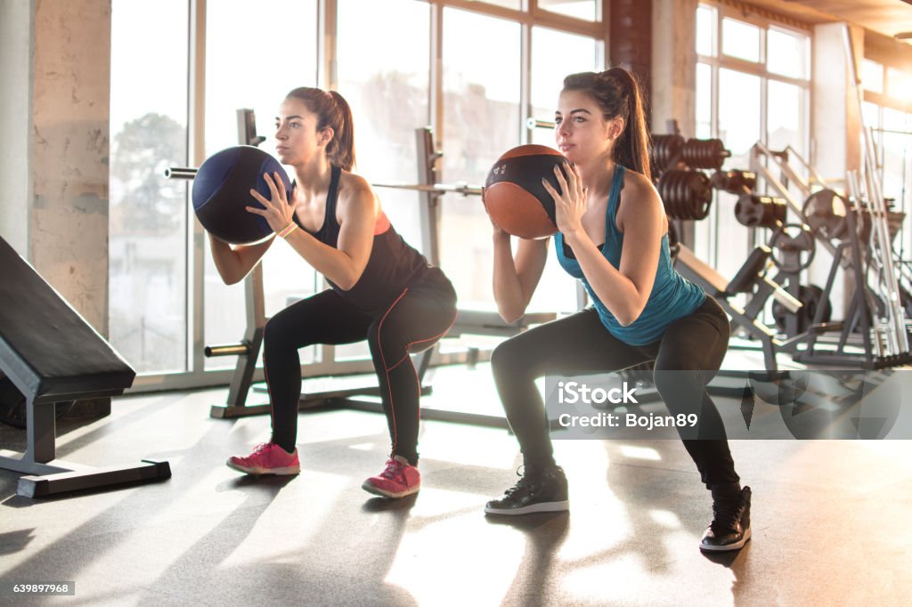 Attractive young women exercising with pilates ball at gym. Exercising Stock Photo