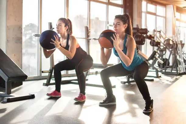 Photo of Attractive young women exercising with pilates ball at gym.