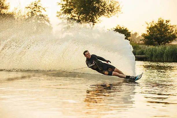 Photo of Athlete doing stunts on wakeboard in lake