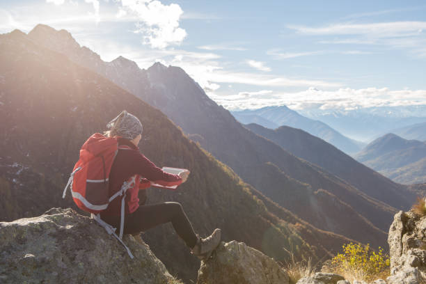 istock Young woman on mountain top looking at digital tablet 639904036