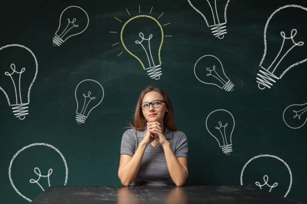 istock Woman looks up on light bulb 639917216