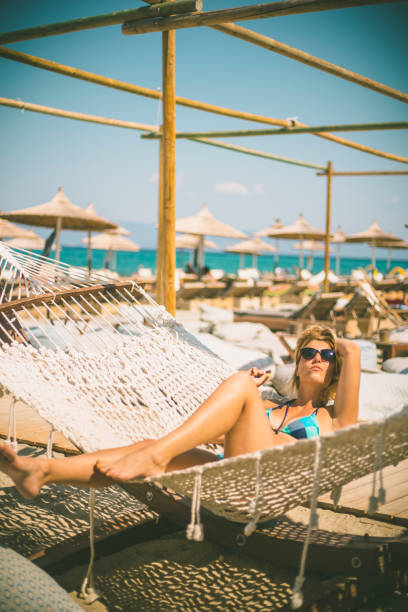 istock Happy young woman lying in hammock on tropical beach 639919856