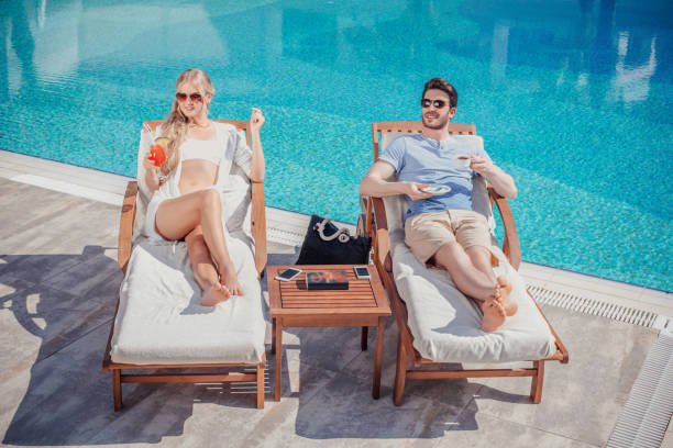 istock Young couple enjoying relaxing vacation poolside at luxury resort 639922674