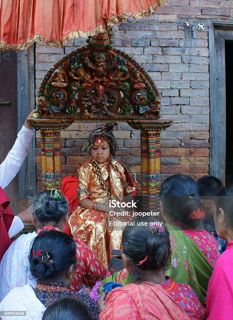 Kumari of Bhaktapur receives offerings by devotees Bhaktapur, Nepal - October 6, 2011: Kumari is the tradition of worshipping a ritual selected young prepubescent girl as manifestation of the divine female energy or devi in Hindu  tradition. Kumari means young unmarried girl (Kumar means unmarried man, both names are also popular first names in Nepal). Asia Stock Photo