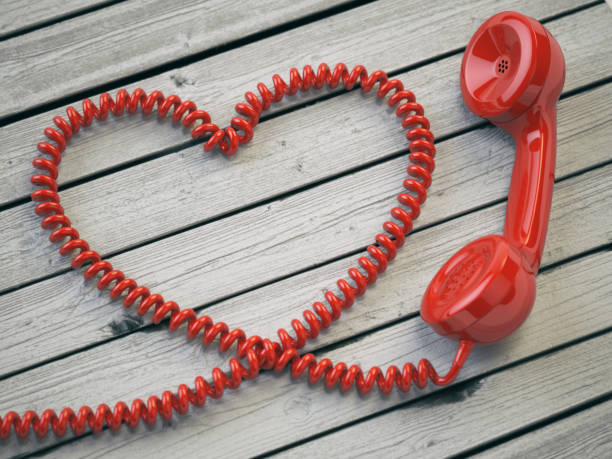 istock Phone reciever and cord as heart on white wooden background. 639929026