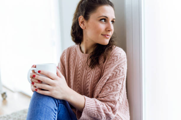 istock Beautiful young woman drinking coffee at home. 639932518