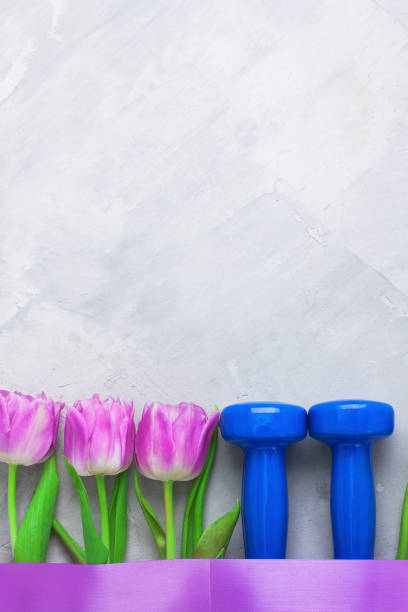 istock Spring flatlay sports composition with blue dumbbells and purple tulips. 639932614