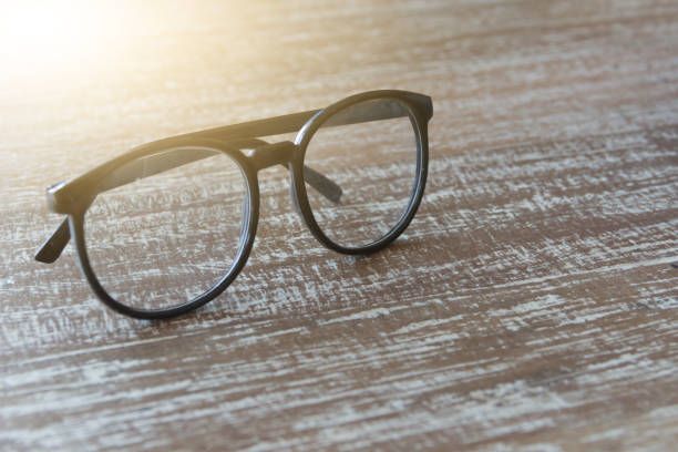 istock Eye glasses on wooden with light ray 639935058