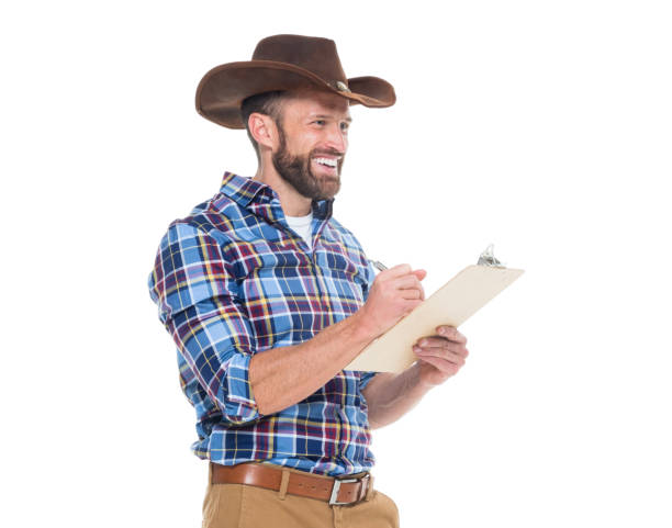 istock Cheerful cowboy writing on clipboard 639944684