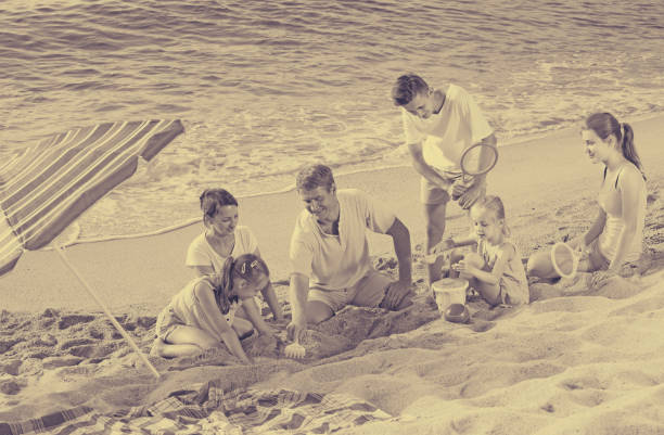 istock family with four kids relaxing on beach 639948366