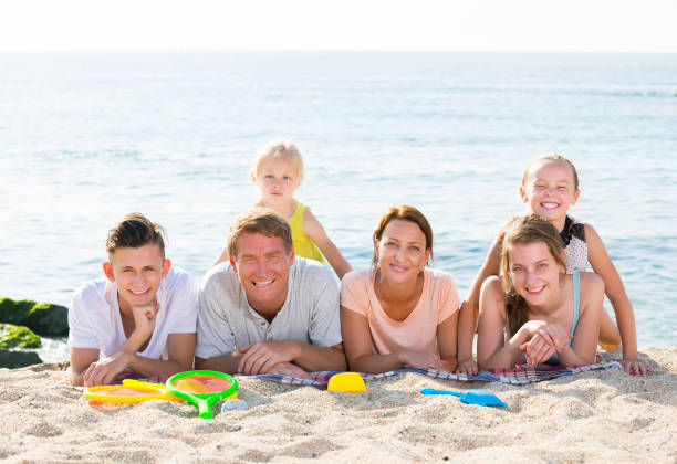 istock Parents with children lying on sand 639949166