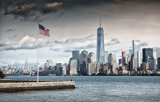 Grey cloud above American Flag overlooking the Freedom Tower, New York City