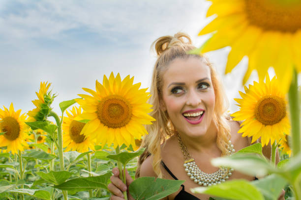 istock Beautiful woman surrounded by sunflowers 639949878