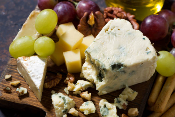 istock cheeseboard, fresh fruits and honey on dark table, top view 639961788