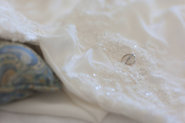 istock Wedding ring lying on the white  dress close-up 639967168