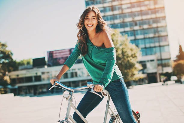 화창한 날에 자전거를 타는 행복한 젊은 여성 - jeans sensuality sex symbol women 뉴스 사진 이미지