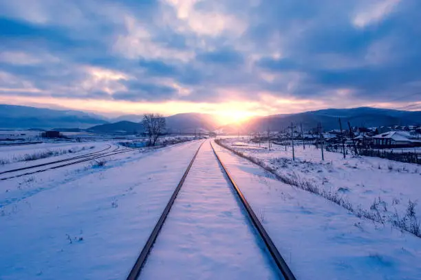 Photo of Winter view of the old railway at sunset time.