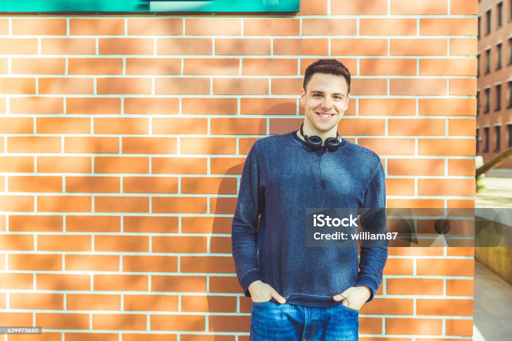 Retrato de joven contra una pared de ladrillo - Foto de stock de Adulto libre de derechos