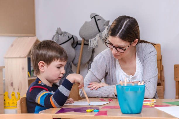 istock Kindergarten Teacher Works With Child 639978624