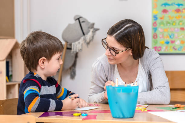 istock Kindergarten Teacher Works With Child 639978684