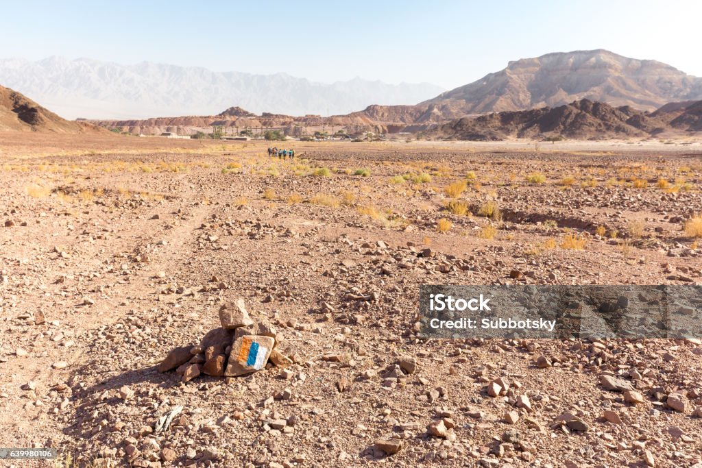 Trail marking stone sign group people hiking backpackers traveli Trail marking stone sign trailblazing group people tourists backpackers hiking walking desert mountains ridge plateau, Shvil Israel traveling backpacking, Negev, Timna park. Backpacker Stock Photo