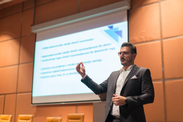 Speaker giving talk at Business Conference.