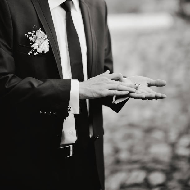 istock Groom showing two wedding rings on his palm 639984440