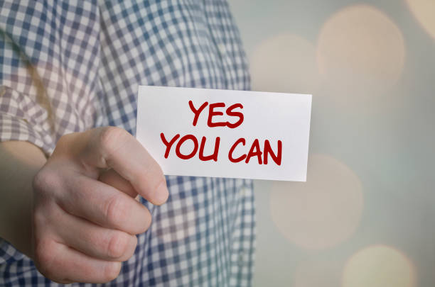 istock Man showing Yes You Can card. Blurred bokeh background. 639985268