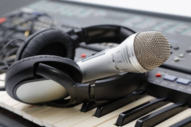istock microphone and ear-phones lie on the keyboard 639986838