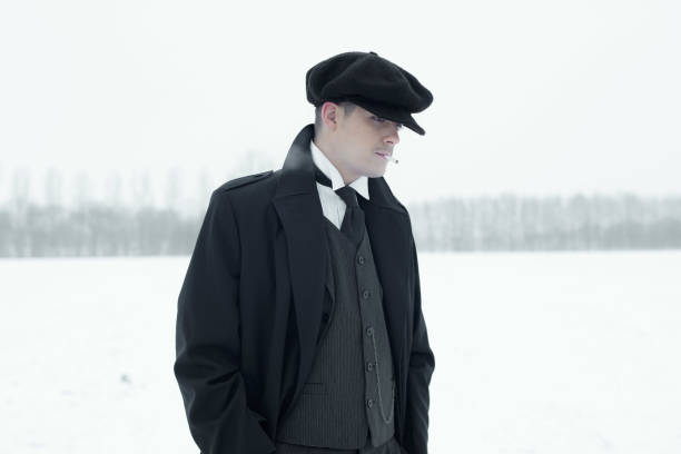 istock Retro 1920s english gangster with black coat and flat cap. 639987114