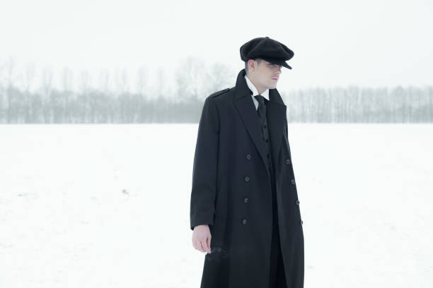 istock Retro 1920s english gangster with black coat and flat cap. 639987160