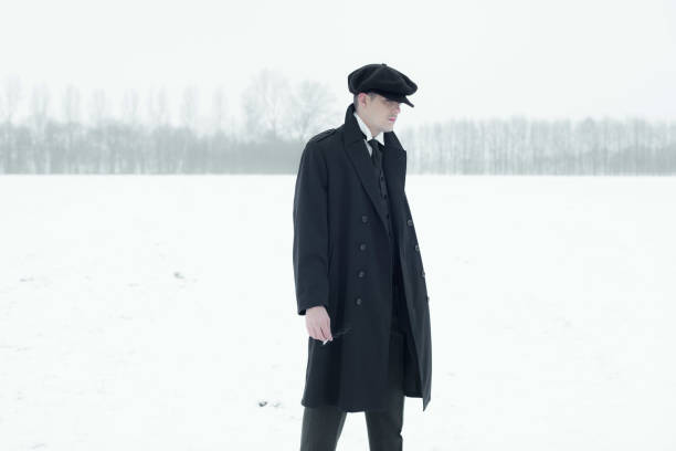 istock Retro 1920s english gangster with black coat and flat cap. 639987178