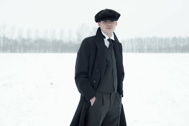 istock Retro 1920s english gangster with black coat and flat cap. 639987208