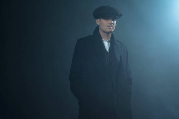 istock Retro 1920s english gangster wearing coat and flat cap. 639987634