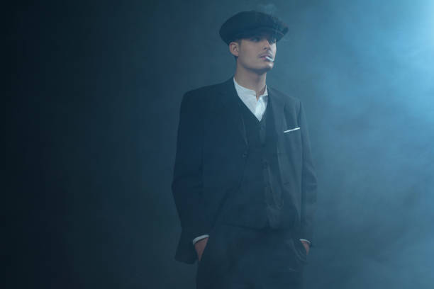 istock Retro 1920s english gangster wearing suit and flat cap. 639987652