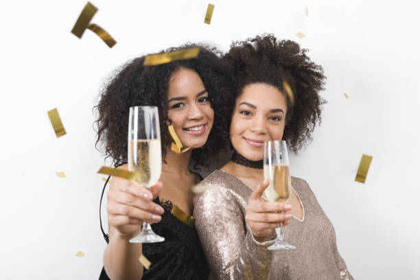 istock Two beautiful brunette women toasting with champagne, confetti 639990966