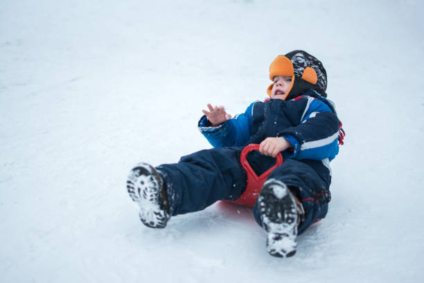istock Little boy having a ride with plastic sled outdoors. 639995758