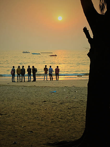 Sunrise over the Arabian Sea Diu, India - November 3, 2016: Young people watching the sunrise over the Arabian Sea on Nagao Beach on Diu Island in Gujarat state. Diu is a popular holiday destination, particularly for Gujaratis, and is linked to the rest of the state by a causeway diu island stock pictures, royalty-free photos & images